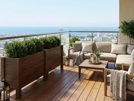 Ahşap saksı düzenleme fikirleri ile tasarlanmış, deniz manzaralı balkonda Dora Long saksılar ve bej köşe koltuk takımı.